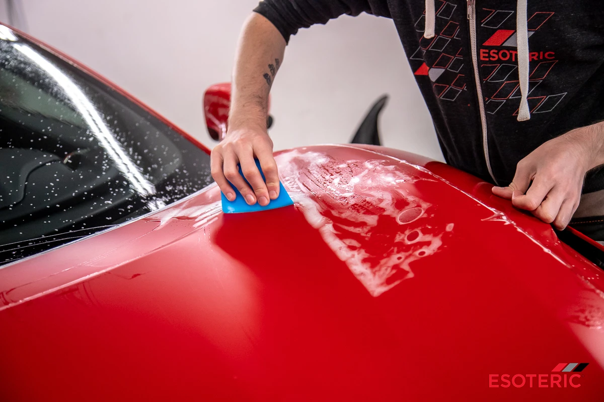 Satin PPF being applied to a Ferrari hood at ESOTERIC